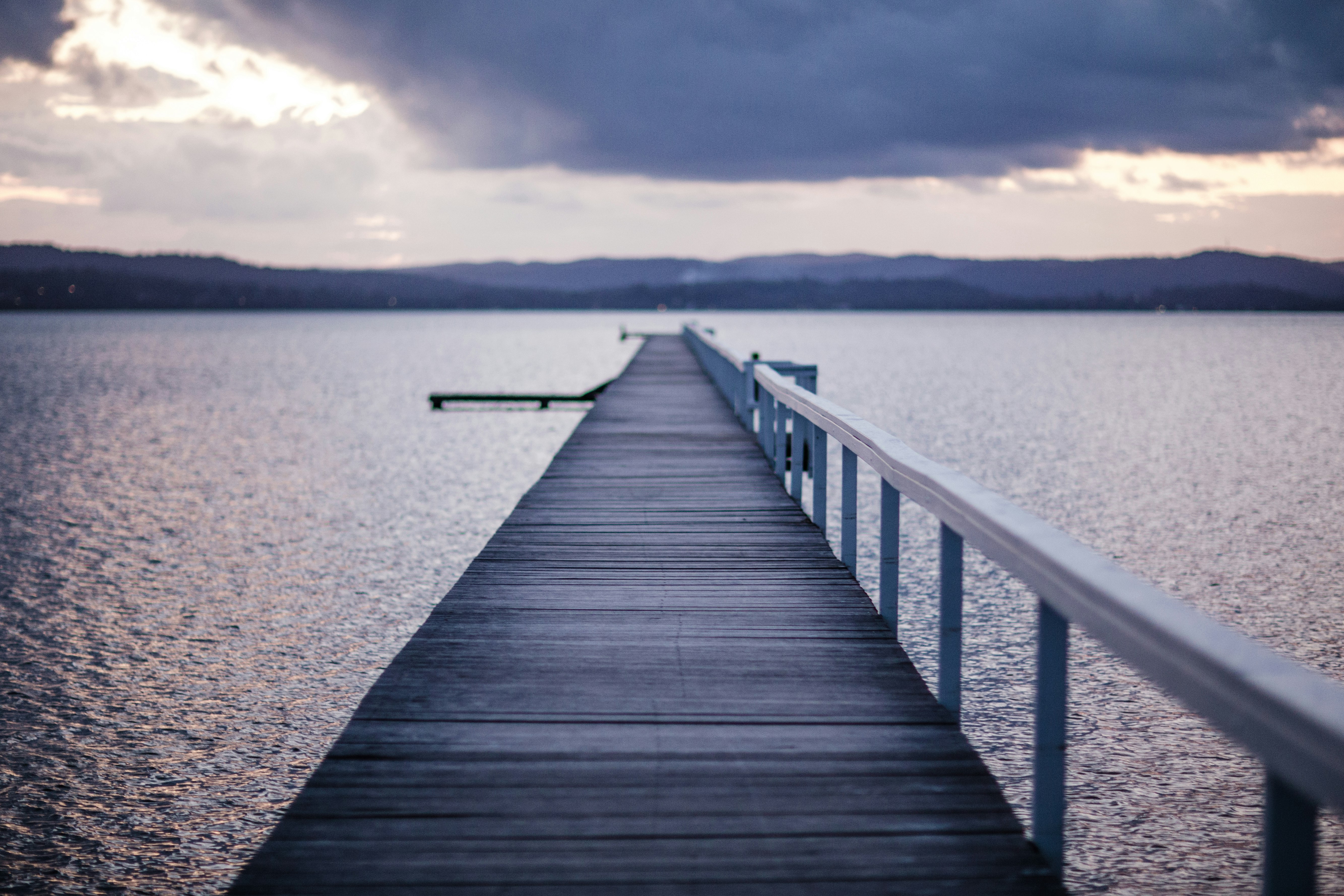 gray boardwalk under cloudy sky